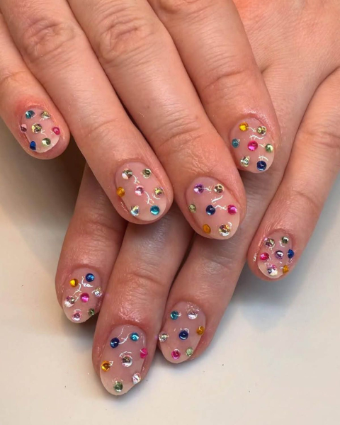 spring 2026 trend rainbow rhinestone gem nails on nude nail polish